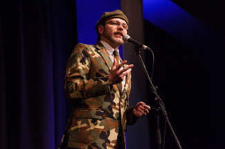 Moderation auf höchstem Niveau mit schrillen Outfits: Michael Jakob (Zirndorf) leitet den Neumarkter Poetry Slam. Fotograf: Valentin Olpp