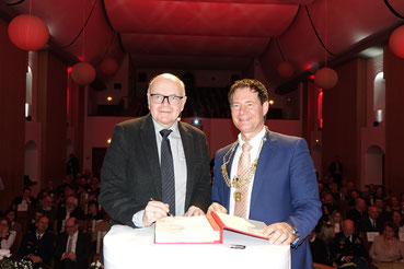Eintrag ins Goldene Buch (links: Prof. Dr. Karlheinz Ruckriegel, rechts: Thomas Thumann); Fotos: Stadt Neumarkt